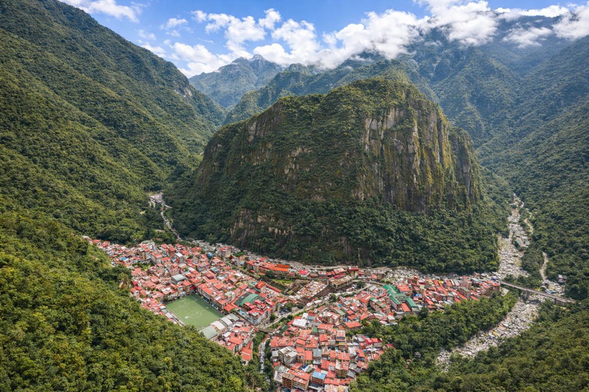 Aerial view of Aguas Calientes surrounded by Andes mountains on a Machu Picchu Guided Tours itinerary.