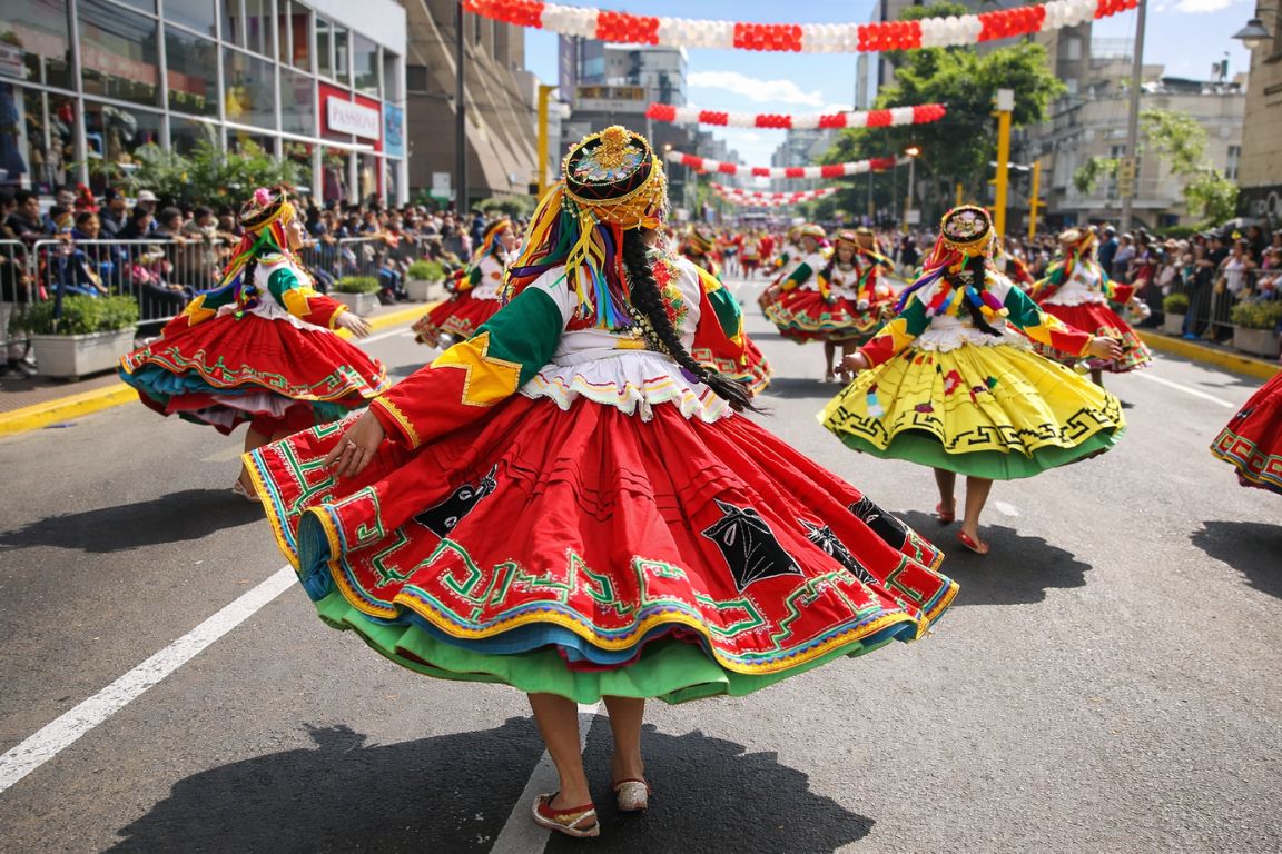 Peruvian Independence Day parade with traditional dancers experienced during a Machu Picchu Guided Tours visit.